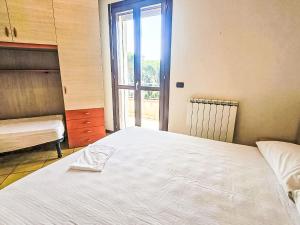 a bedroom with a large white bed and a window at Apartment Mairen-3 by Interhome in Rosolina Mare