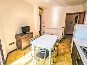 a kitchen with a white table and a refrigerator at Apartment Mairen-3 by Interhome in Rosolina Mare