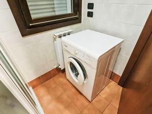 a washer and dryer in a small room at Apartment Mairen-3 by Interhome in Rosolina Mare +4 photos