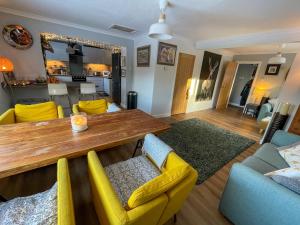a living room with a wooden table and yellow chairs at Stags View in Invergarry
