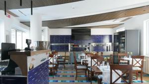 a restaurant with tables and chairs and a kitchen at Hotel Miramare in Maiori