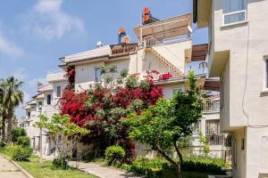 a building with a flowering tree in front of it at Güneş Villa Bahçe Katı in Antalya
