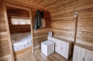 a cabin with a bed in a wooden room at Schlaffass direkt am See in Heideblick