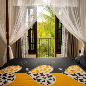 a bedroom with a bed with a large window at Sunrise Eco Resort in Matara