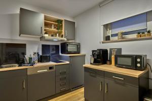 a kitchen with gray cabinets and a tv on the counter at zeitlang by angelika kodewitz in Waldsassen