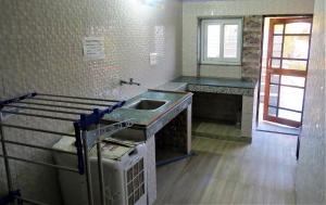 a kitchen with a sink and a counter top at Swami Manjulanand Ashram in Mohan Chatti