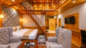 a bedroom with a bed and two chairs and a staircase at Regal Retreat Inn in Shirir