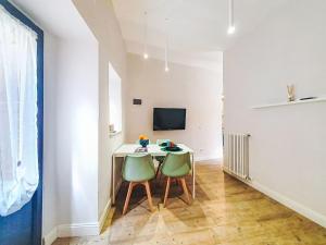 a dining room with a table and two green chairs at Apartment Studio Kalè Akté by Interhome in Caronia