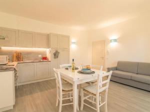a kitchen and living room with a white table and chairs at Apartment Nuraghi by Interhome in Arzachena