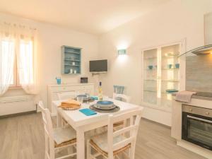a kitchen and dining room with a white table and chairs at Apartment Nuraghi by Interhome in Arzachena