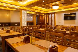 a dining room with wooden tables and chairs at Regal Retreat Inn in Shirir