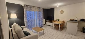 a living room with a couch and a table at Appartement T2 lac Léman in Publier