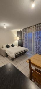 a bedroom with a bed and a large window at Appartement T2 lac Léman in Publier