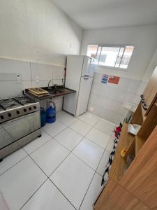 a kitchen with a stove and a refrigerator at Refúgio Aconchegante Solares in Petrolina