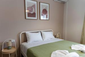 a bedroom with a green bed with two towels on it at Mea Casa Comfort Home in Pitsidia