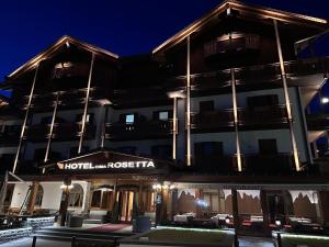 a building with a hotel rocca at night at Hotel Cima Rosetta, WorldHotels Distinctive in San Martino di Castrozza