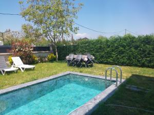 a swimming pool in a yard with chairs and a table at Orkide Sapanca in Sapanca