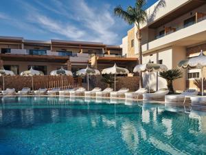 a swimming pool with chairs and umbrellas next to a building at Lesante Classic - Preferred Hotels & Resorts in Tsilivi