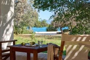 a wooden table with a drink and fruit on it at Hydra Beach Resort in Thermisía