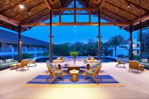 a large patio with a table and chairs at OUTRIGGER Khao Lak Beach Resort in Khao Lak