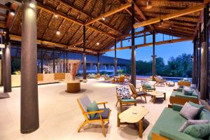 a pavilion with chairs and tables and a lounge area at OUTRIGGER Khao Lak Beach Resort in Khao Lak