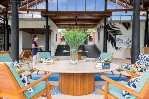 a table with chairs and a vase with flowers at OUTRIGGER Khao Lak Beach Resort in Khao Lak +122 photos