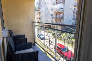 a balcony with chairs and a red car on a street at Banja Koviljača Apartmani Matić in Banja Koviljača