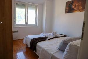 a bedroom with two beds and a window at Banja Koviljača Apartmani Matić in Banja Koviljača