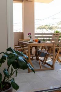 a wooden table and chairs on a balcony at Mea Casa Comfort Home in Pitsidia