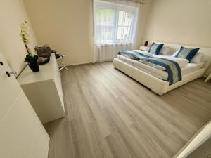 a bedroom with a bed and a wooden floor at Moseloase am Weinberg mit Pool und Sauna in Bullay in Alf +4 photos