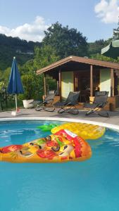 a swimming pool with a person laying on a raft at Moseloase am Weinberg mit Pool und Sauna in Bullay in Alf
