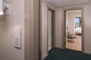 a hallway with a door to a room with a bedroom at ME by Meliá Sitges Terramar in Sitges