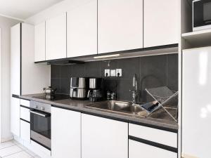 a kitchen with white cabinets and a sink at Apartment Brömsebro by Interhome in Halmstad
