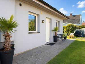 a white house with a potted plant on a patio at Apartment Brömsebro by Interhome in Halmstad