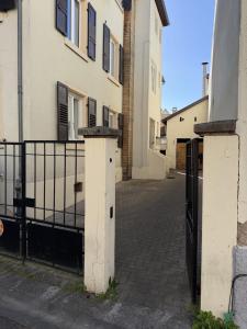 an empty street with a gate and some buildings at L'Écrin Beige - Moderne - Portes de Strasbourg in Schiltigheim