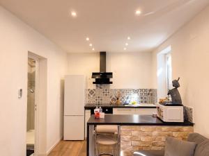 a kitchen with a refrigerator and a counter top at L'Écrin Beige - Moderne - Portes de Strasbourg in Schiltigheim