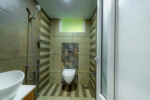 a bathroom with a toilet and a sink and a shower at Floresta Resort in Kūmudi
