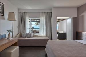 a hotel room with two beds and a couch at Hydra Beach Resort in Thermisía