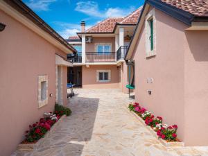 a courtyard of a home with pink houses and flowers at Holiday Home Šimić by Interhome in Dušić