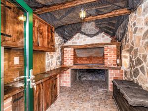a kitchen with a brick fireplace in a room at Holiday Home Šimić by Interhome in Dušić