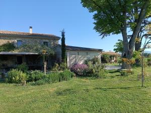 a house with a tree in the yard at La Bohême La Belle Etoile Petit déjeuner compris in Charols