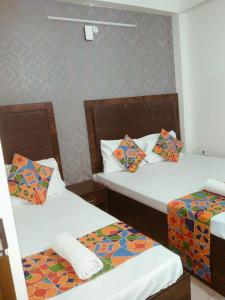 two twin beds in a room with at HOTEL TIRUMALA VAIBHAv in Secunderabad