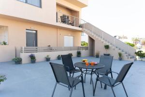 a patio with a table and chairs in front of a building at Mea Casa Comfort Home in Pitsidia