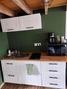 a kitchen with white cabinets and a sink and a microwave at Studio Dennebroeucq in Dennebroeucq