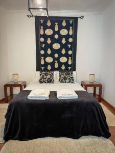a bedroom with a bed with two towels on it at Villa Reis - Boutique House in Golegã
