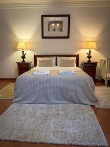 a bedroom with a large bed with two towels on it at Villa Reis - Boutique House in Golegã