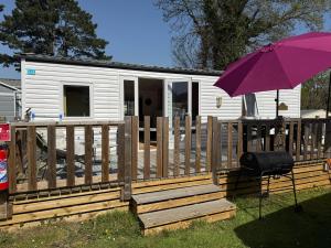 a purple umbrella sitting next to a mobile home at Camping paradis in Clohars-Carnoët