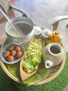 a tray with a sandwich and eggs and a pot of coffee at วิวดี ป่าเหมี้ยง โฮมสเตย์ in Ban Pa Miang