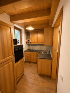 a kitchen with wooden cabinets and a black appliance at Al Vagone in La Salle