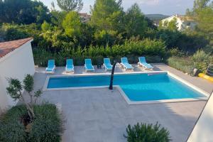 a swimming pool with lounge chairs and a swimming pool at Villa Mare in Ližnjan